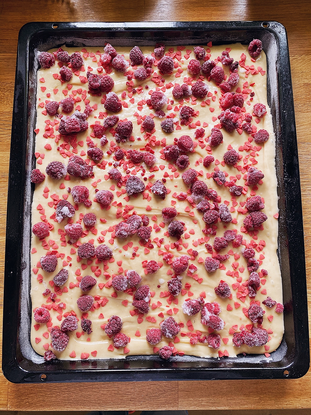Himbeerkuchen vom Blech mit rosa Herzchen-Streusel-Frosting